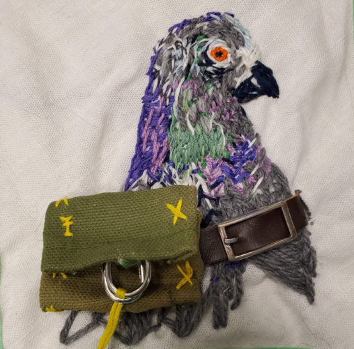 embroidery of a carrier pigeon with a back pack